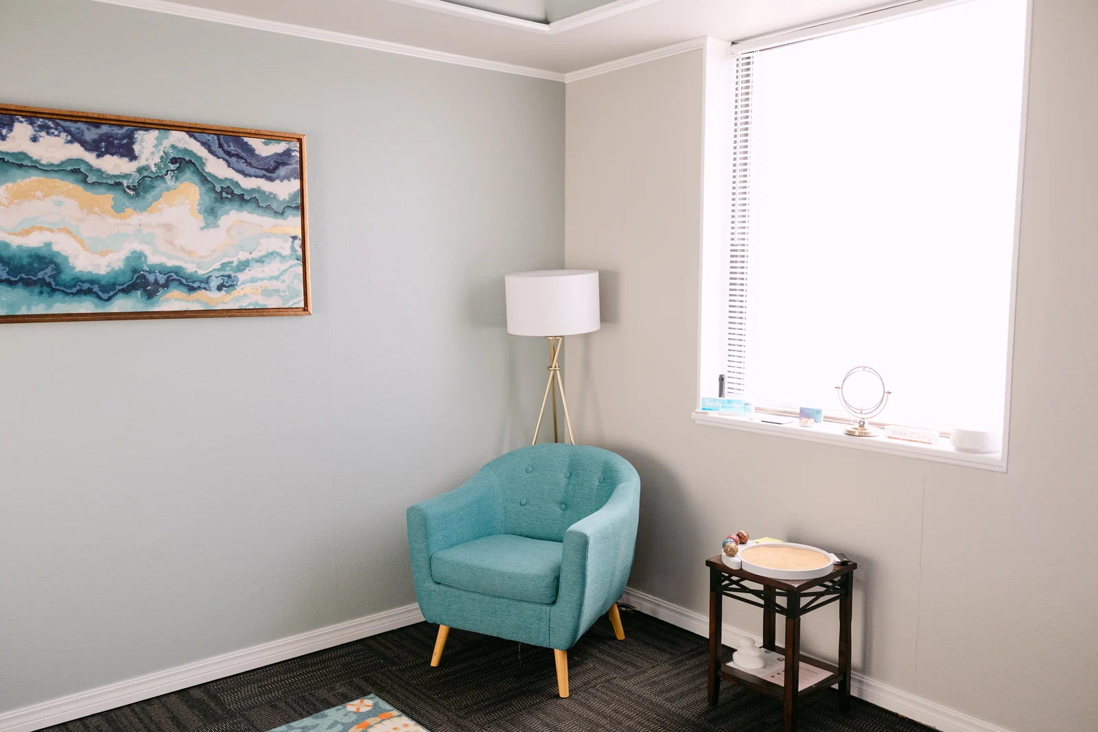 A teal armchair in the bright W.M. Health and Wellness therapy office